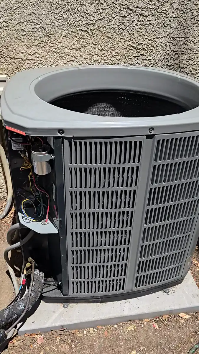 El compartimiento eléctrico abierto del condensador durante la reparación, con el capacitor de marcha y el cableado a la vista