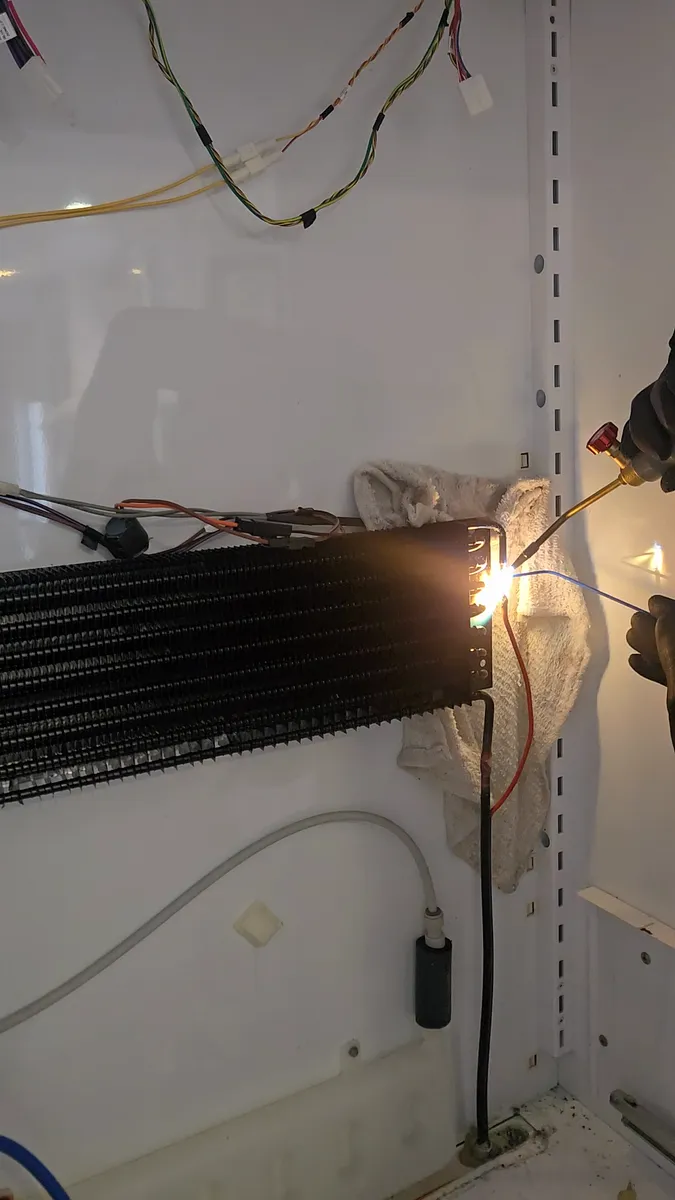 Soldadura del tubo capilar durante el cambio del evaporador del refrigerador