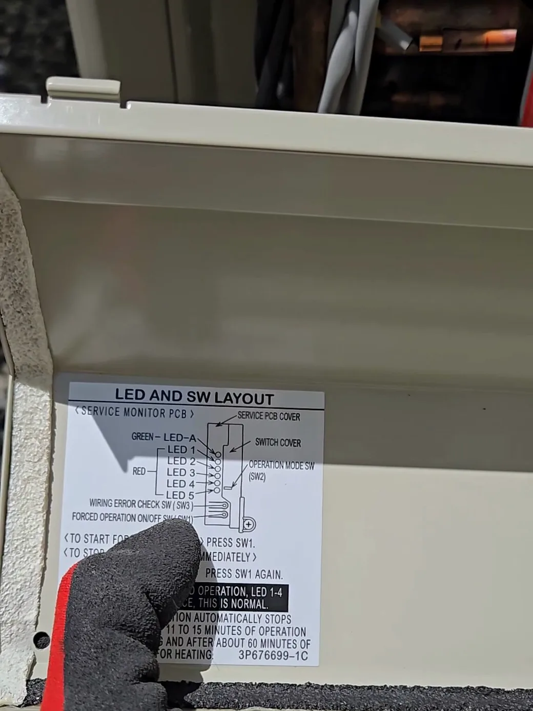 La etiqueta de servicio en la placa de la unidad exterior — el interruptor del chequeo de conexiones que inicia el autodiagnóstico de Daikin.