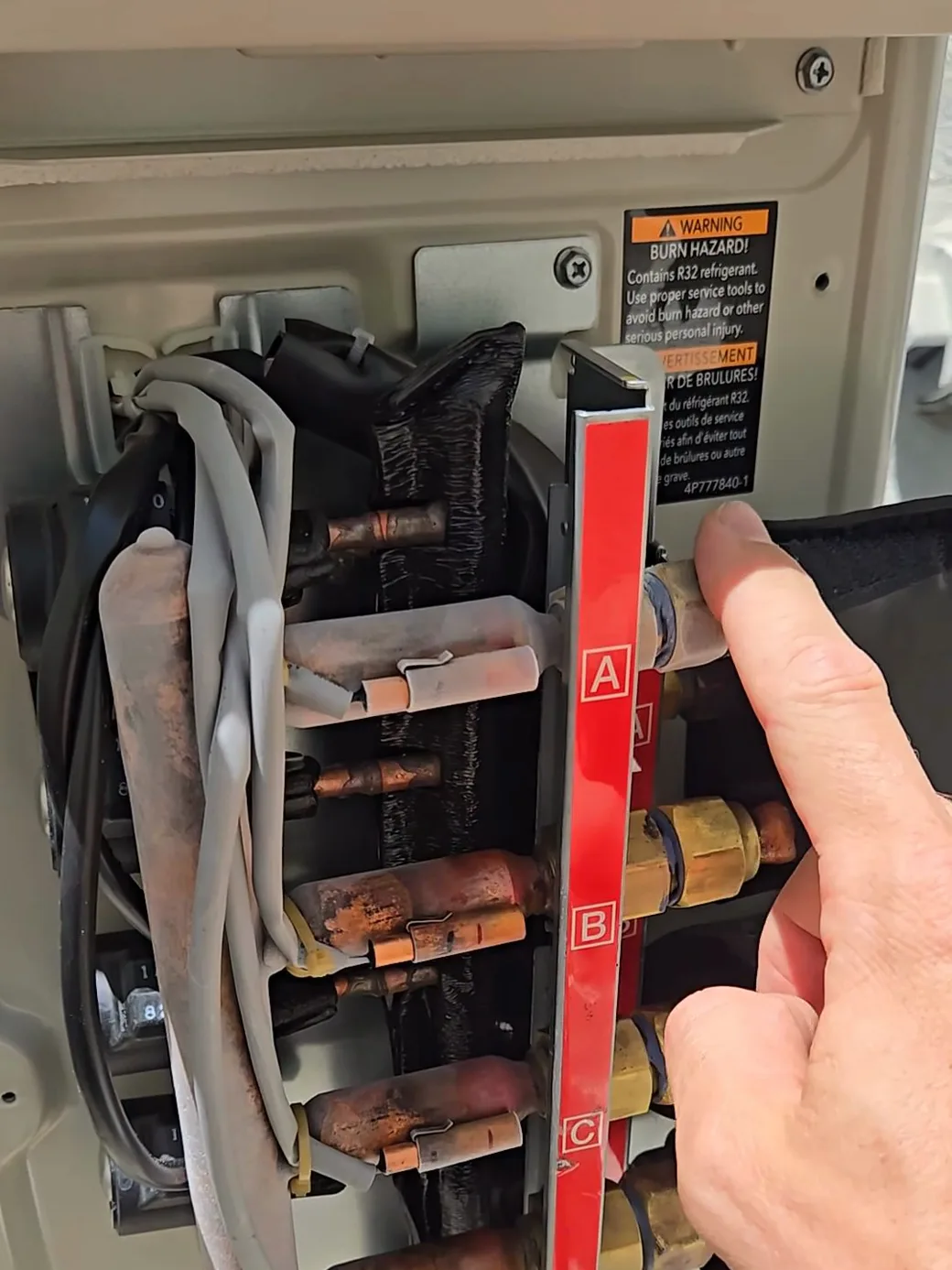La línea de refrigerante escarchada de la zona que estaba apagada — refrigerante frío fluyendo por una unidad sin flujo de aire.