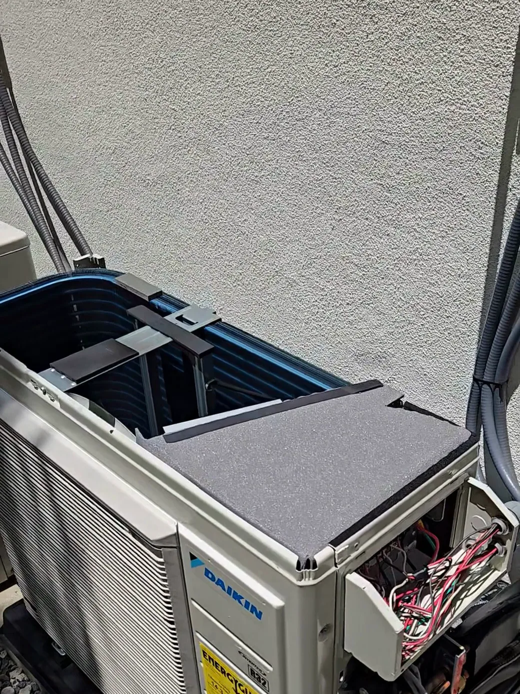 Unidad exterior de un mini split Daikin multi-zona nueva con el panel de servicio abierto durante el diagnóstico en Los Ángeles.
