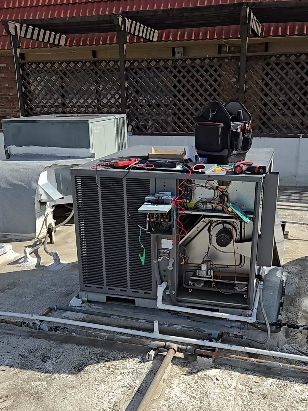 Un técnico trabajando en un equipo paquete comercial de HVAC en el techo de una farmacia de Los Ángeles.