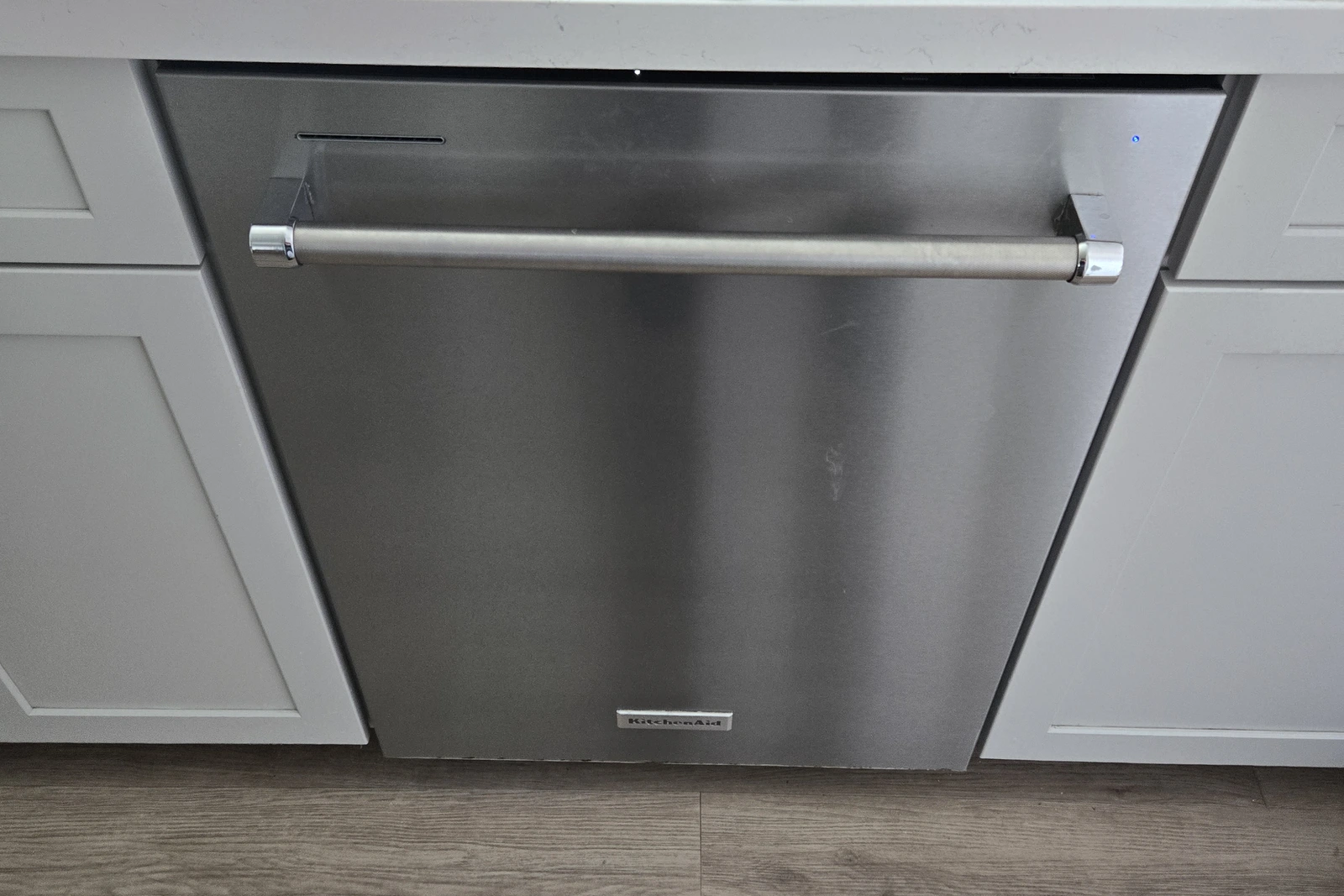 Built-in KitchenAid dishwasher with a stainless steel door in a Los Angeles kitchen before the repair