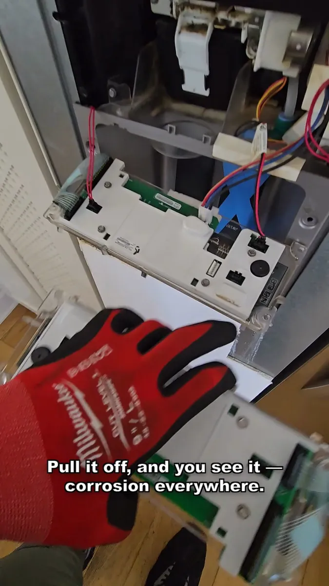 Panel de control del dispensador corroído tras retirarlo de la puerta del KitchenAid