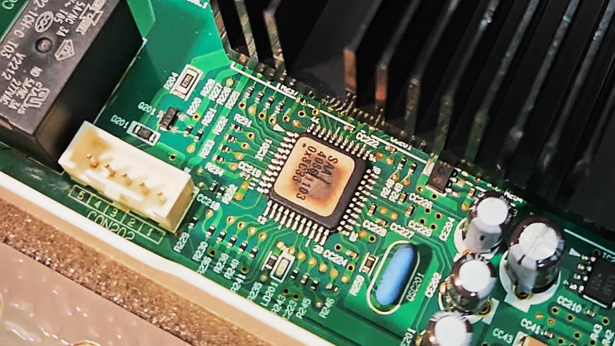 Close view of the burnt control microcontroller on the refrigerator inverter board