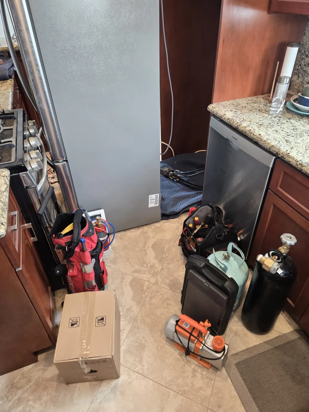 Máquina de recuperación de refrigerante, bomba de vacío y tanque de nitrógeno listos en la cocina para un cambio de compresor de sistema sellado LG en Los Ángeles.