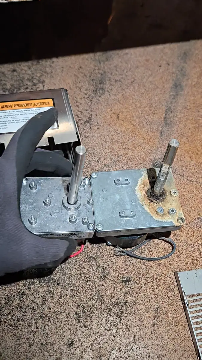 Old and new glasswasher gearmotors side by side on the floor