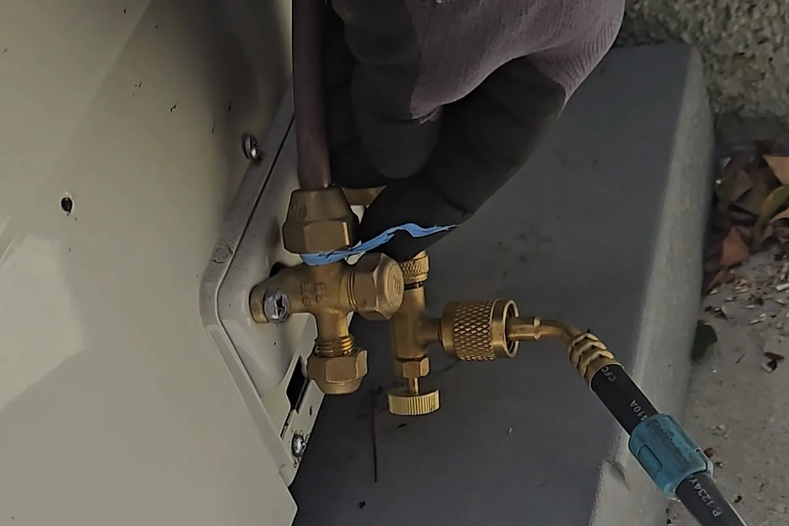 Refrigerant-line flare fitting wrapped with plumbing Teflon tape at the leaking connection
