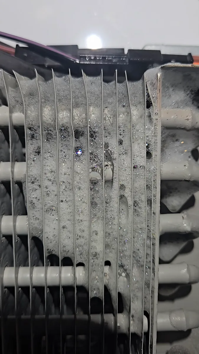 Espuma detectora de fugas sobre el evaporador de un refrigerador Viking empotrado durante el diagnóstico de fuga de refrigerante en Los Ángeles