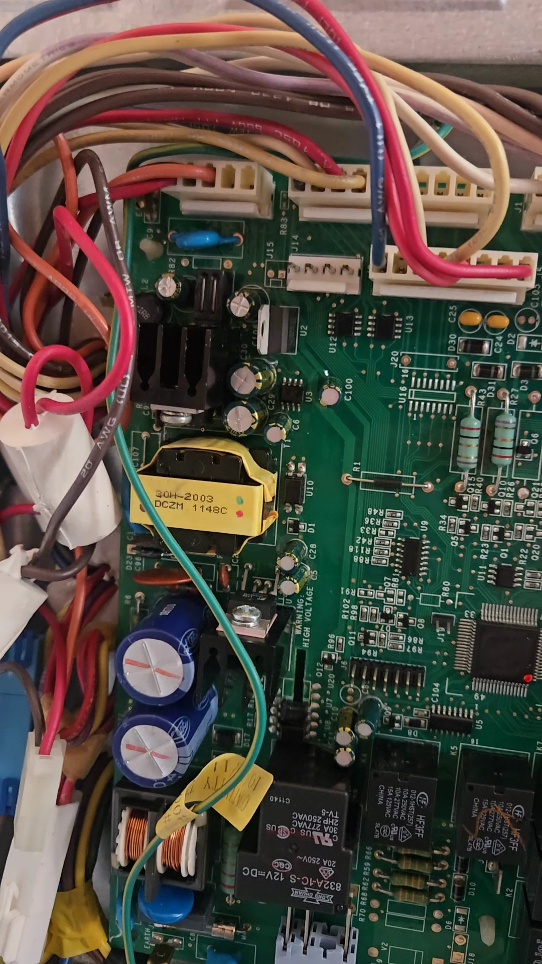 The rebuilt control board fitted behind the refrigerator.