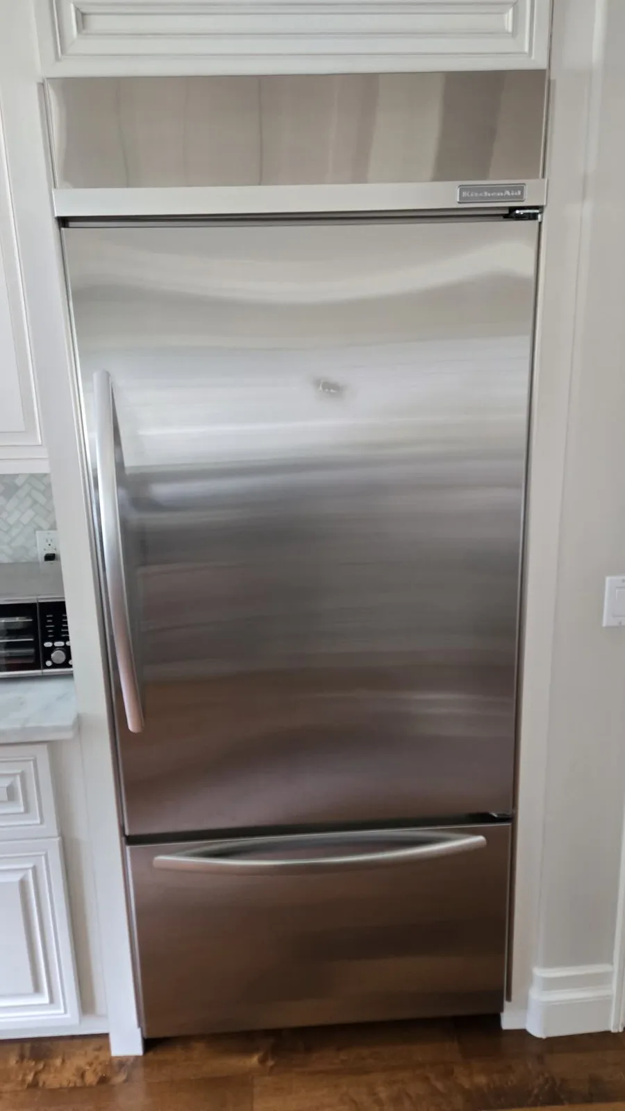 Built-in stainless KitchenAid refrigerator in a Los Angeles kitchen before the repair