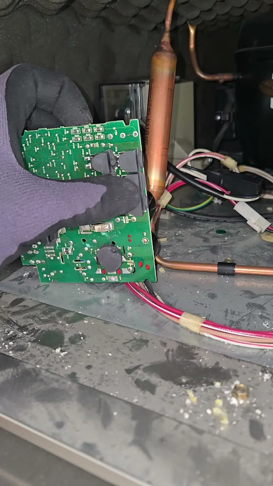 Failed original KitchenAid inverter board after removal, with the grey silicone thermal pads visible on the back