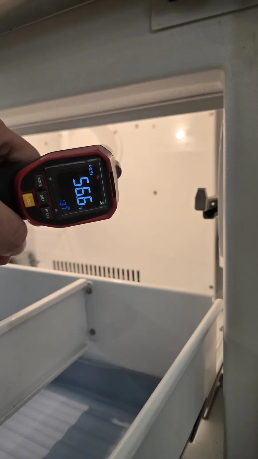 Infrared thermometer reading 56.6°F inside the freezer of the KitchenAid refrigerator after the inverter board replacement