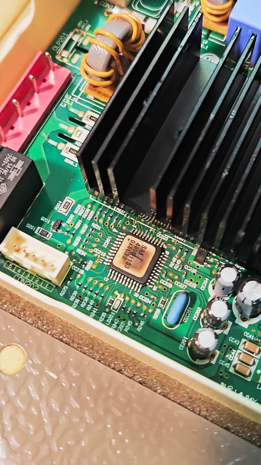 Close view of the control microcontroller chip on the inverter board with a scorched, brown top
