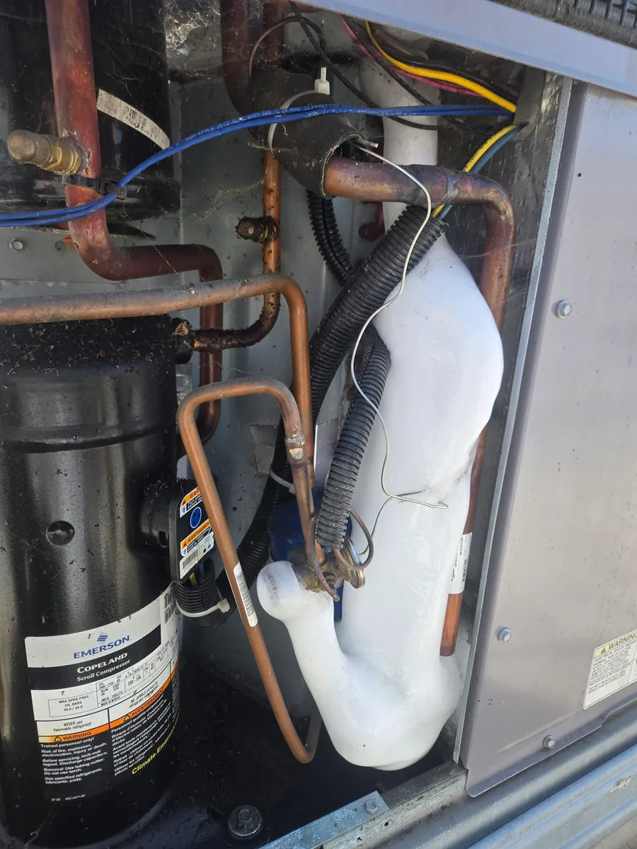 Ice visible on components inside a packaged HVAC unit during service