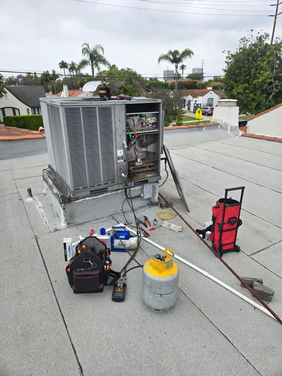 Rooftop HVAC unit opened for repair with refrigerant tank and tools by Epic Star in Hancock Park, Los Angeles